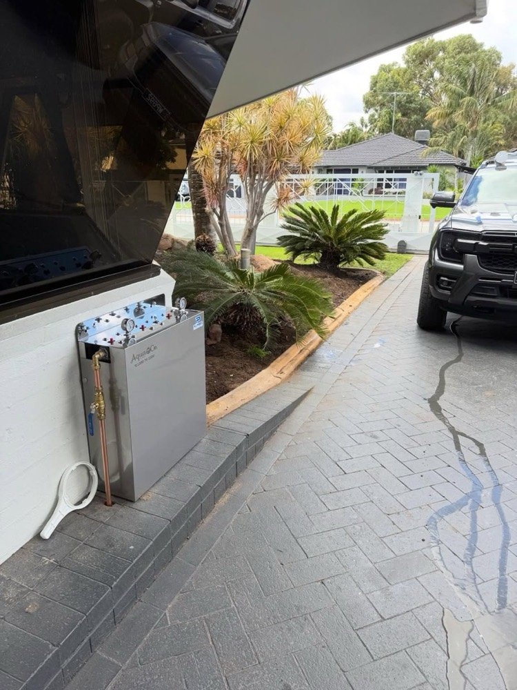 AquaCo whole-home filtration unit installed beside a driveway