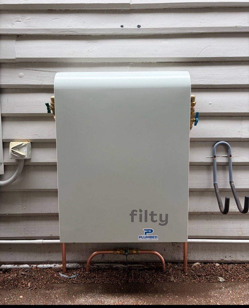 Filty whole-home filtration unit installed on a weatherboard home