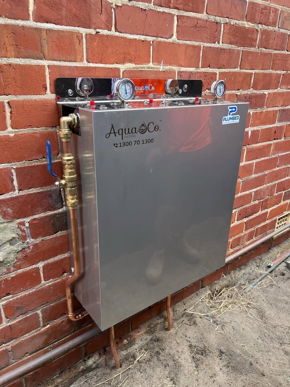 Whole-home filtration unit installed on a brick wall